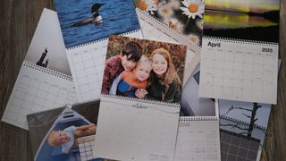 A collection of several custom photo calendars on a wood background