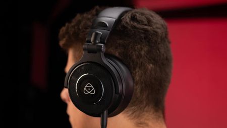 Person wearing Atomos StudioSonic headphones against a black and red background 