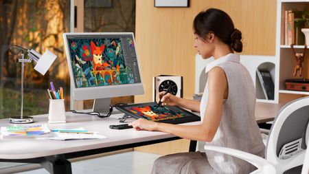XP-Pen Artist Ultra 16 lifestyle image showing person sat at computer using the pen display 